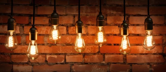 Fotobehang Rustic Vintage Light Bulbs Casting Warm Glow Against Textured Brick Wall Background © Gular