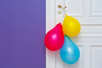 White wooden door decorated with three colorful balloons - 758205571