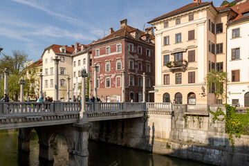 Fototapeta na wymiar Ljubljana, Slovenia; Beautiful buildings along the promenade of the navigable Ljubljanica river in the city center of Ljubljana, Slovenia.