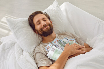 Young rich man sleeps with pile of cash and smiles with satisfaction in his sleep. Caucasian man...