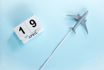 April calendar with number  19. Top view of a calendar with a flying passenger plane. Scheduler....