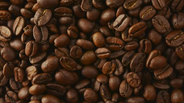 Roasted coffee beans rotate. View from above.