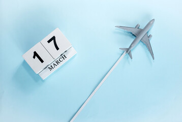 March calendar with number  17. Top view of a calendar with a flying passenger plane. Scheduler. Travel concept. Copy space.