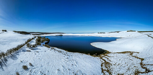 Panoramic photo of a lake in the heart of the aubrac in France with a snowy valley, drone photo, Travel destination, nature walk, snowy landscape natural reservoir