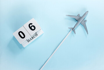 March calendar with number  6. Top view of a calendar with a flying passenger plane. Scheduler....
