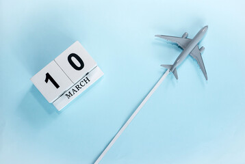 March calendar with number  10. Top view of a calendar with a flying passenger plane. Scheduler....