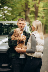 happy young couple with a dog in the forest