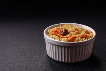 Delicious pilaf with vegetables, salt, spices and herbs in a ceramic plate