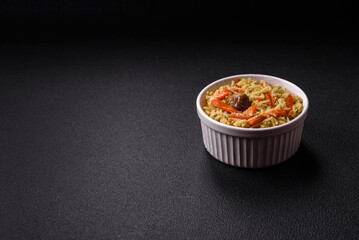 Delicious pilaf with vegetables, salt, spices and herbs in a ceramic plate