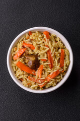 Delicious pilaf with vegetables, salt, spices and herbs in a ceramic plate