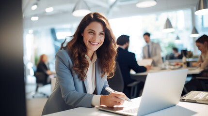 Fototapeta premium Happy woman working on a laptop in the office