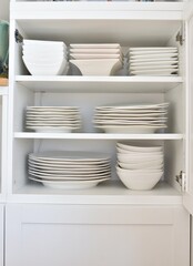 Kitchen dish cabinet neatly organized with family dishes and crockery. Photo concept, home life, background, organization