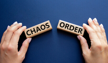 Chaos or Order symbol. Concept word Chaos or Order on wooden blocks. Businessman hand. Beautiful deep blue background. Business and Chaos or Order concept. Copy space