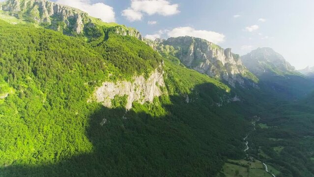 Shooting from a drone of high mountains and a beautiful valley at sunset