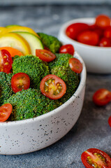 Top view photograph of a healthy bowl or salad with broccoli, tomato, lettuce, cucumber and zucchini
