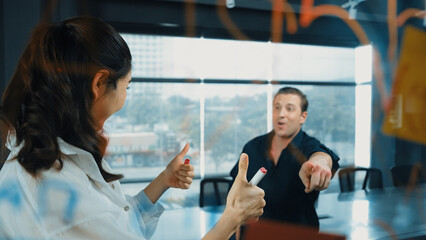 Young confident businesswoman present project to expert investor. Professional project manager uses sticky notes to explain startup project, sharing brainstorming ideas to investor. Manipulator.