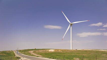 wind turbine in the field next to a road