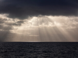 Sun between the clouds illuminating the iceland coast at sunset