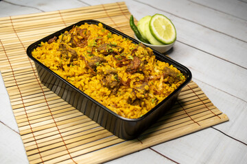 beef khichuri biryani rice pulao with cucumber and lemon slice served in dish isolated on wooden table side view of bangladeshi and indian spicy lunch food