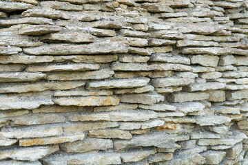 A fragment of a medieval wall made of thin stone slabs.