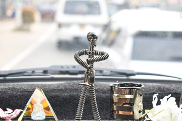 A few statues of lord buddha and some toys on a car dashboard, Sri Lanka.