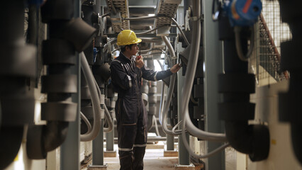 Engineer inspects pipes in a factory - 758250963