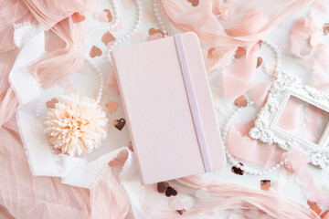 Pink hardcover notebook near hearts and romantic pink decor top view, textbook mockup