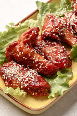 Obraz premium Portion of cooked chicken wings in sauce and sesame seeds