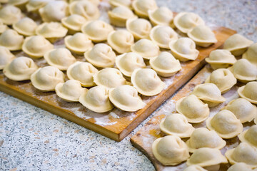 Homemade dumplings close-up. handmade dumplings on a wooden board, selective focus, tinted image, traditional Russian dish,
