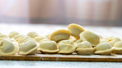 Homemade dumplings close-up. handmade dumplings on a wooden board, selective focus, tinted image, traditional Russian dish,