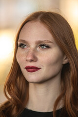 Naklejka premium Portrait of a young beautiful red-haired girl outdoors.