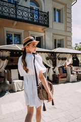 The image features a person wearing a white dress and hat, holding a purse 6437.