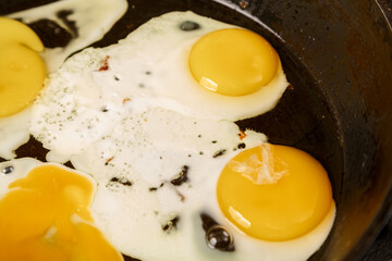 Scrambled eggs are fried in a frying pan in oil close-up