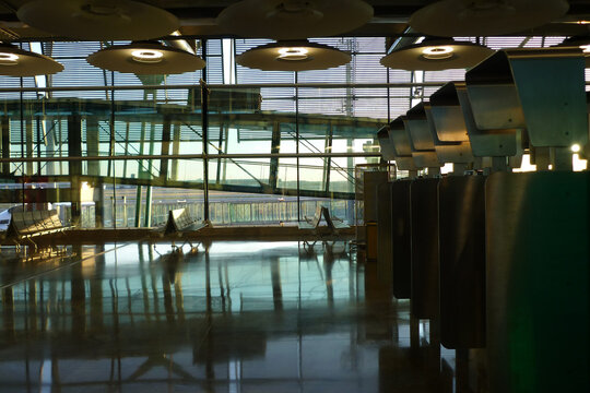 Waiting room at Orly airport in Paris, France. Building interior with benches, lamps and glass wall overlooking the airplane take-off and landing runway. Travel and tourism concept. Copy space.