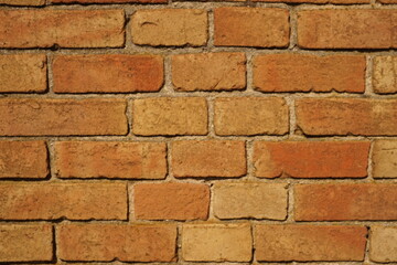 Old red brick wall background in warm sunlight