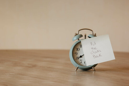Alarm-clock with post-it and the word "put the clocks back". Put the clocks back. Time management concept. Winter Time. daylight saving time