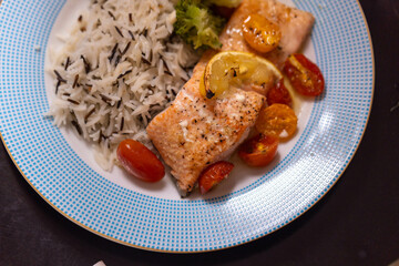 Baked salmon with lemon tomatoes rice and broccoli