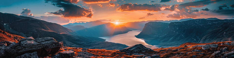 Breathtaking panoramic landscape of a rugged fjord illuminated by a spectacular sunset, suggesting...