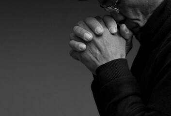 man praying to god with hands together Caribbean man praying stock photo	