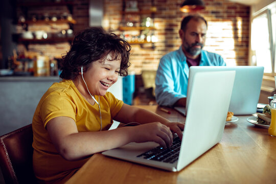 Father and son using laptops at home