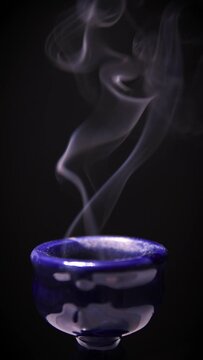 4K vertical footage of incense burner against black background. Censer against black background