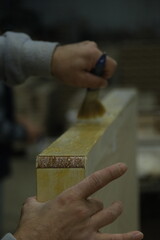 carpenter applying glue on wood with a brush