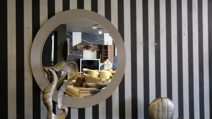 striped wall and wall mirror hanging on the wall