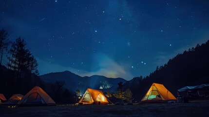Glowing tents under a starry sky in a mountain campsite