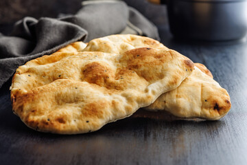 Freshly Baked Naan Bread Resting on a Dark Wooden Table