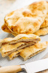 Freshly Baked Naan Bread on citting board on kitchen table.