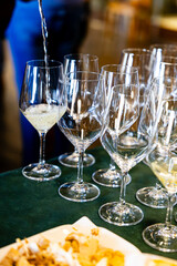 Pouring white wine into elegant glasses for tasting.