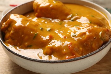Tasty chicken curry on wooden board, closeup