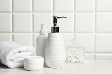 Fototapeta na wymiar Different bath accessories and personal care products on white table near tiled wall