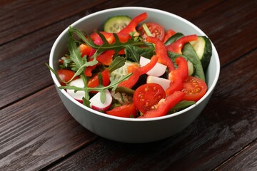 Tasty fresh vegetarian salad on dark wooden table